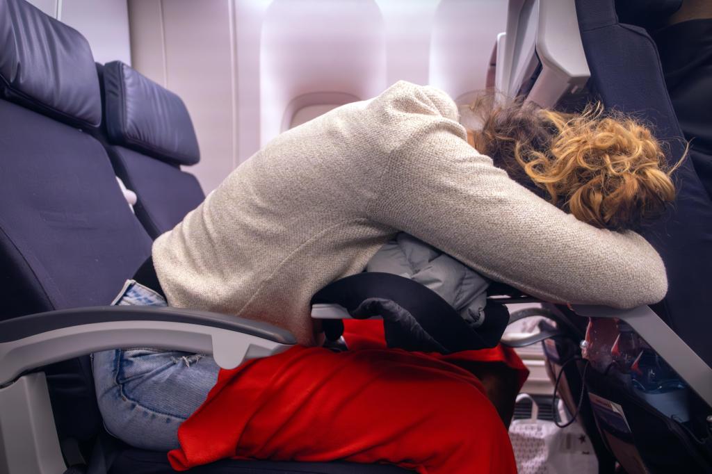 Woman who was awkward sleep in a plane seat.